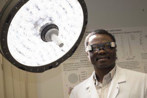 Samuel Achilefu, PhD, the Michel M. Ter-Pogossian Professor of Radiology, oversees a variety of cancer-fighting projects. They include development of goggles that help surgeons see and remove cancer and a therapy that uses a combination of light and a photosensitizing drug to kill malignant cells. (Photo: Robert Boston/Washington University School of Medicine)