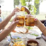 Friends Toasting Iced Tea Glasses At Outdoor Table