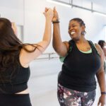 Cheerful Women Giving Each Other High Five At Dance Class