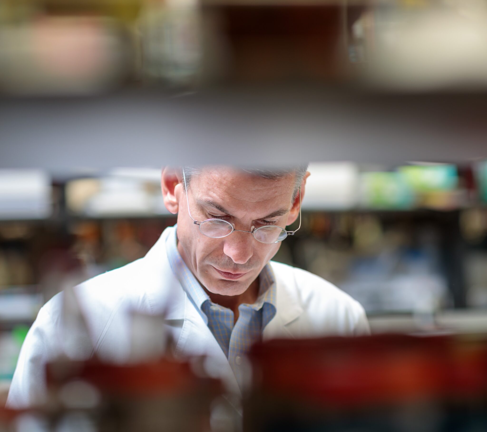 Header Image of Matthew Walter, MD wearing a white lab coat, working in a lab setting, overseeing cancer research grants at Siteman