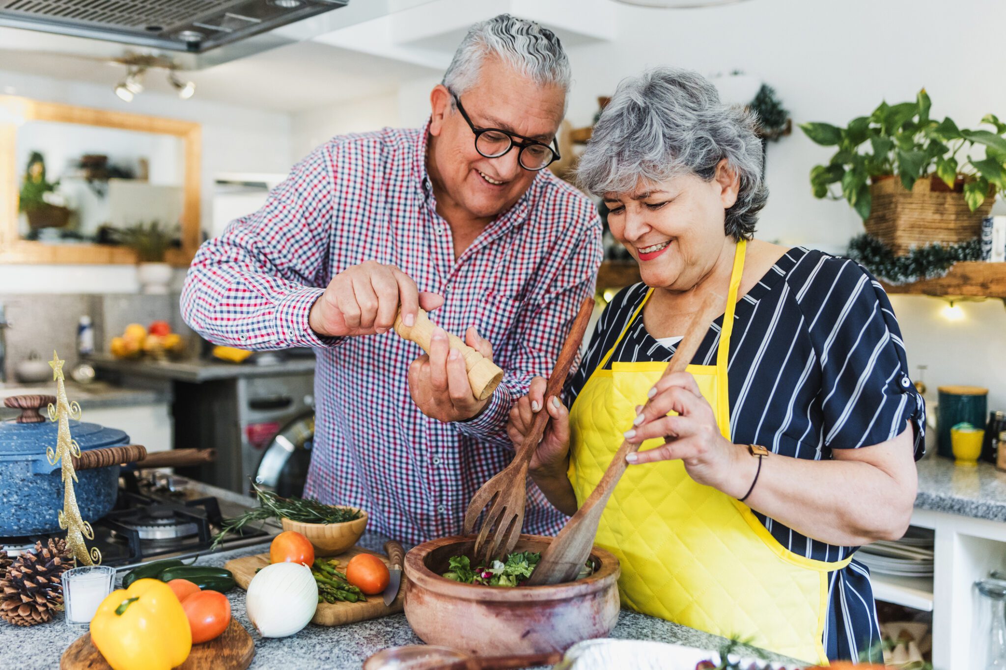 Senior Couple Cooking Dinner At Home In Latin America