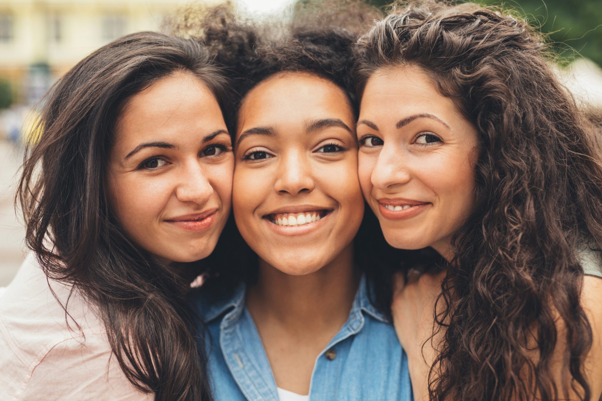 Three women with dark hair pose for a selfie