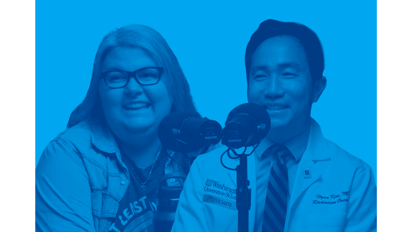 Portrait photo in blue tones of two people smiling in front of a podcast microphone