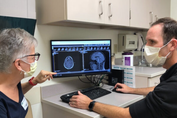 Patient Kim Garland (left) reviews a scan with Tanner Johanns, MD, PhD.